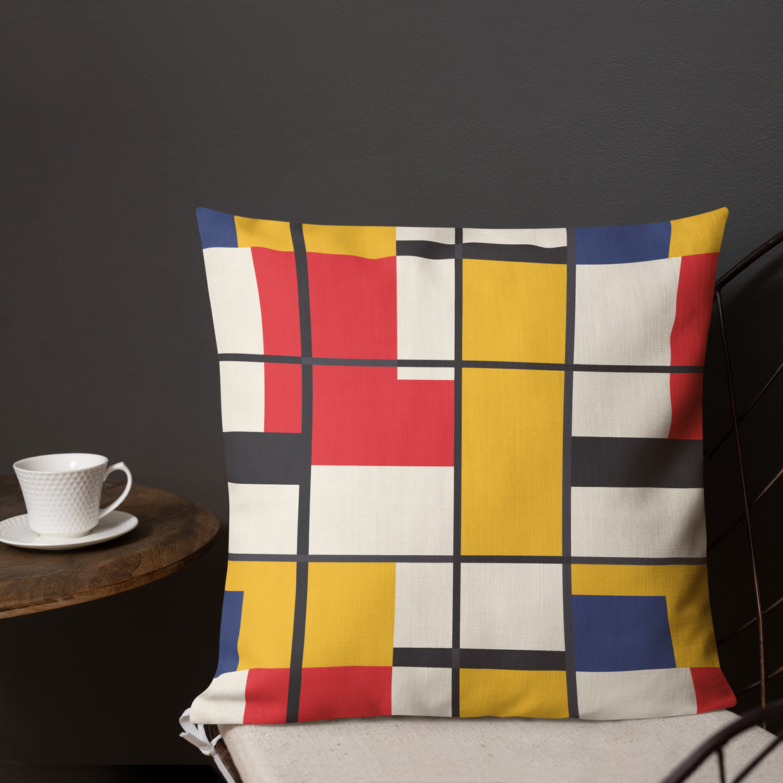 Vibrant geometric design pillow with red, yellow, blue, and white colors on a dark background.