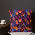 Pillow with a vibrant autumn leaf pattern featuring orange, blue, and magenta hues on a dark background.