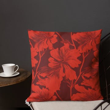 Red pillow with vibrant hibiscus floral pattern on a maroon background