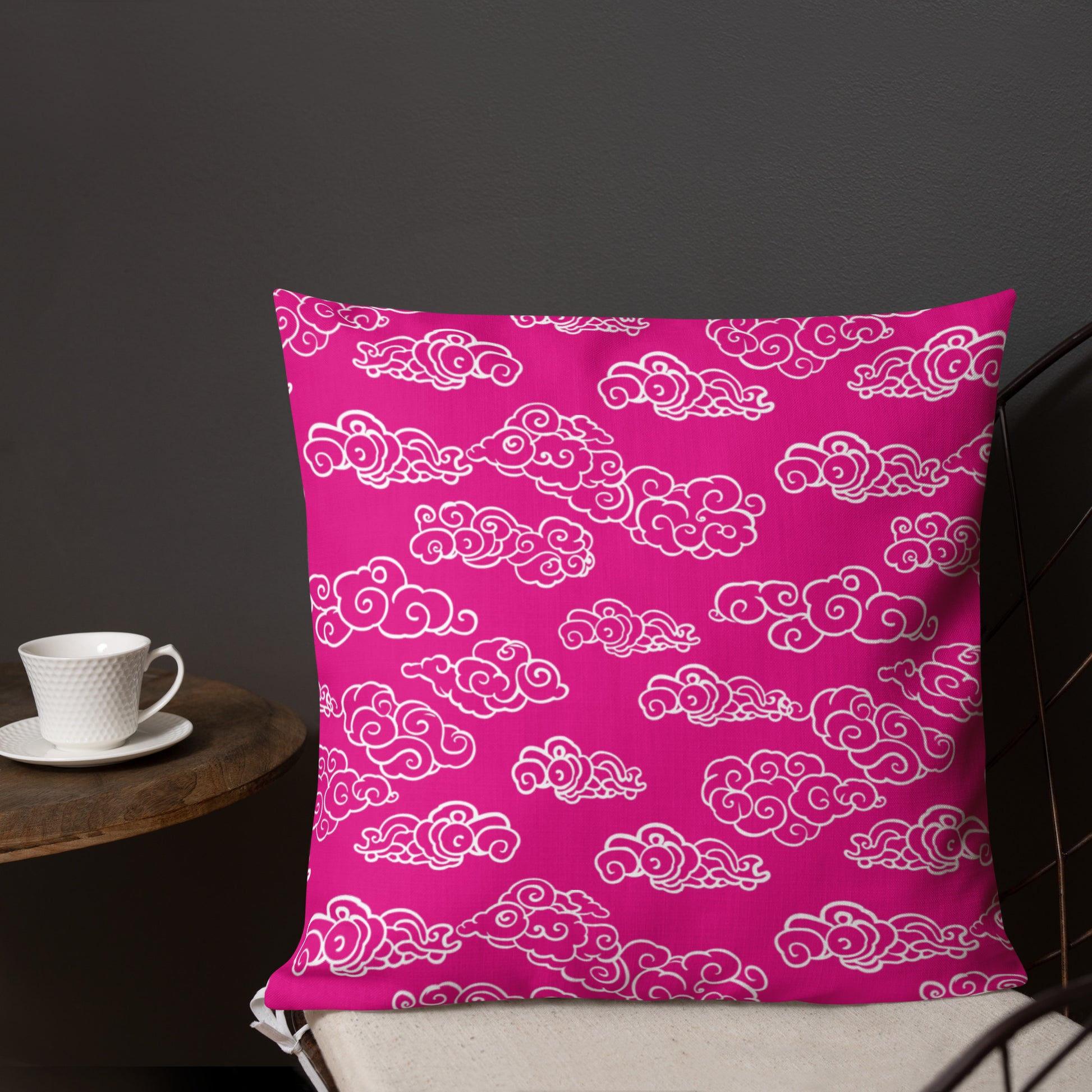 Pink pillow with white cloud knitted pattern, vibrant home decor accent.