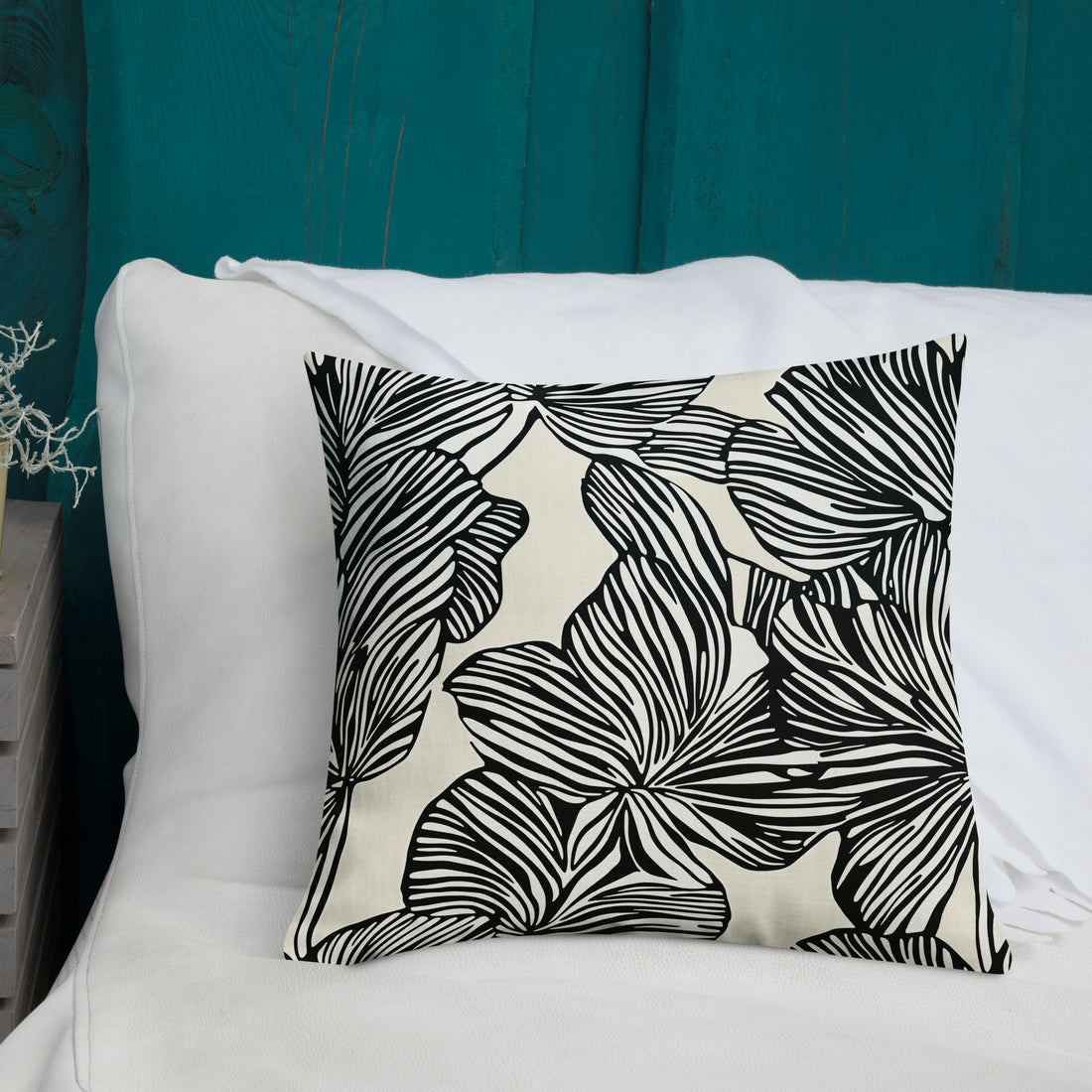 Black and white tropical leaf pattern on a knitted pillow. Modern home decor with a comfy, fabric.