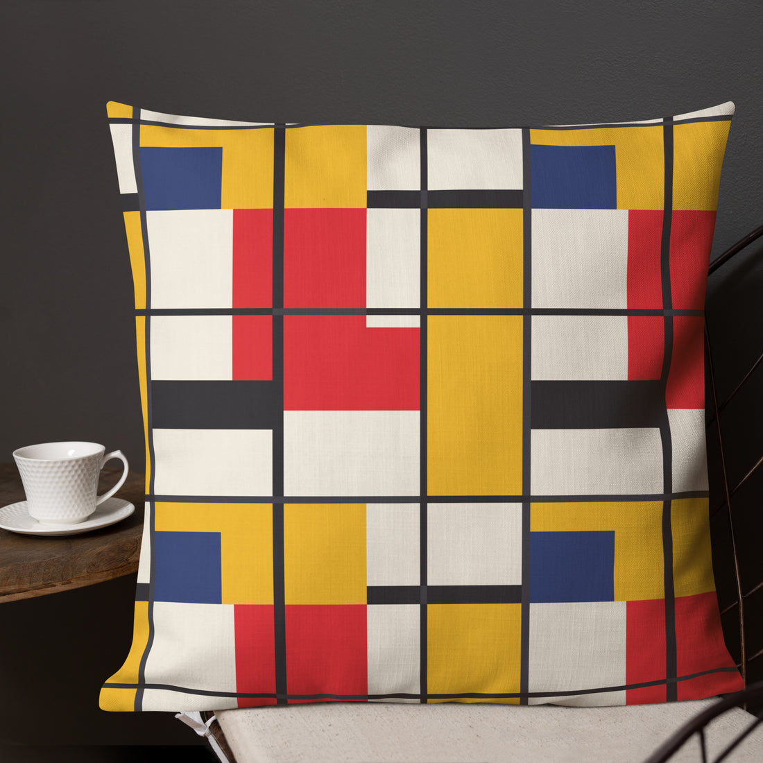 Vibrant geometric design pillow with red, yellow, blue, and white colors on a dark background.