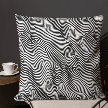 Modern black and white wave design pillow on a home décor setting.