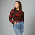 Eco-friendly floral long-sleeve crop top with vibrant red flowers on a black background, model wearing jeans.