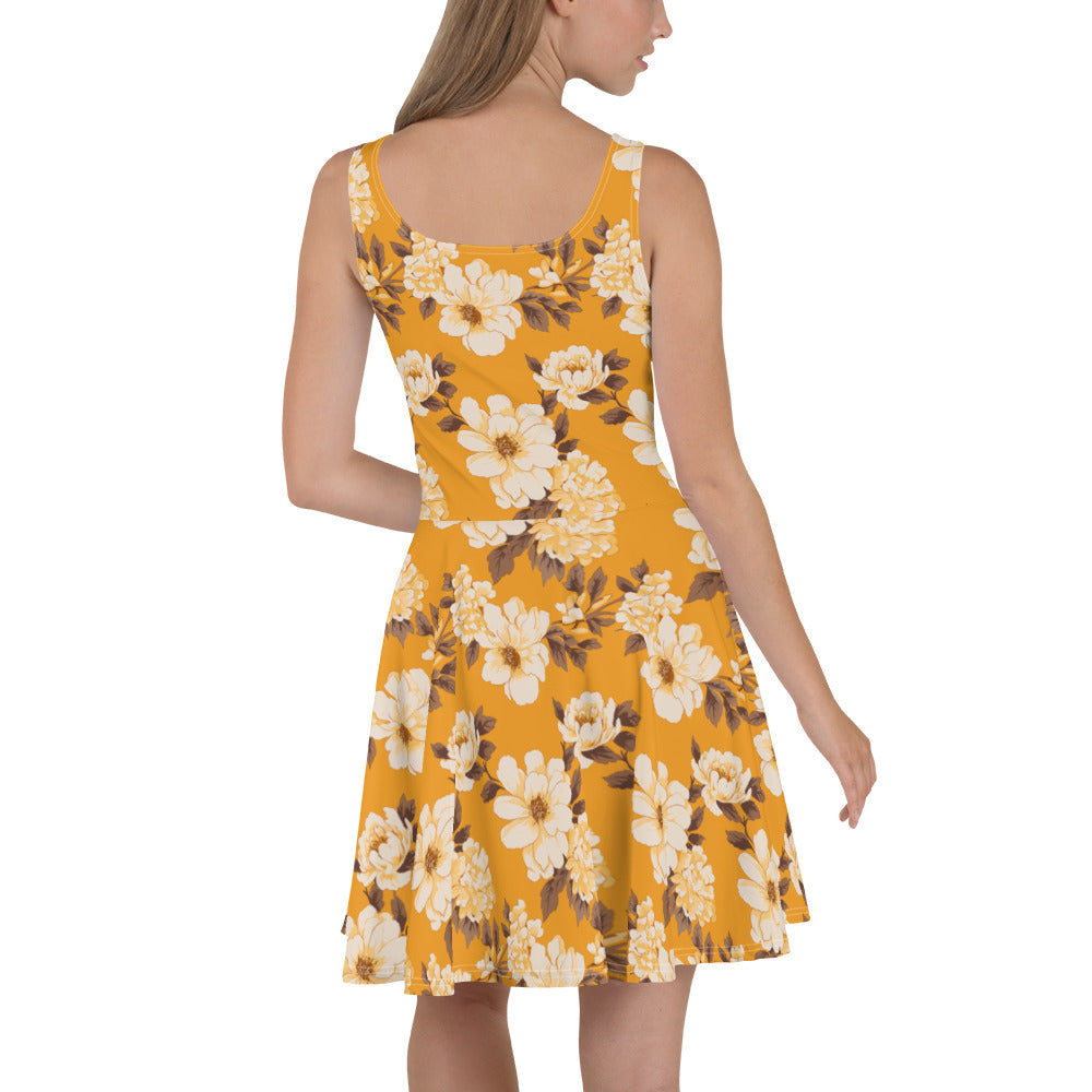 A model wearing a vibrant floral skater dress with a yellow background featuring large white and brown flowers.