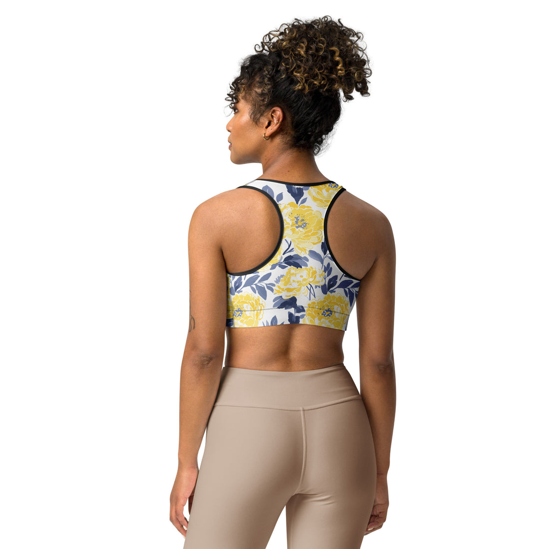 Woman wearing Floral Bloom Sports Bra with vibrant yellow floral design and navy leaves.