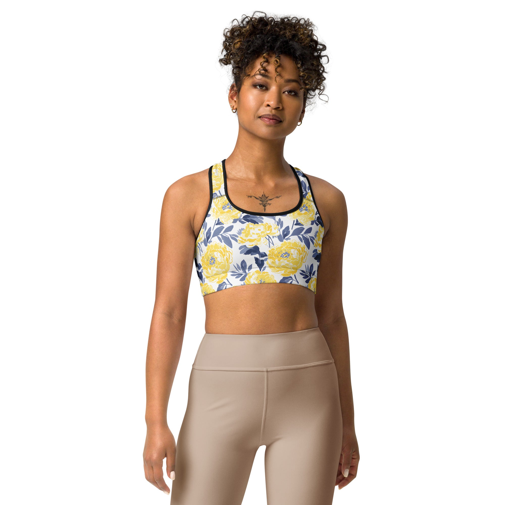 Woman wearing Floral Bloom Sports Bra with vibrant yellow floral design and navy leaves.