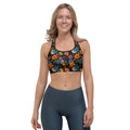 Model wearing a black sports bra with vibrant tropical floral patterns in orange, red, and blue, designed for low to medium-intensity workouts.