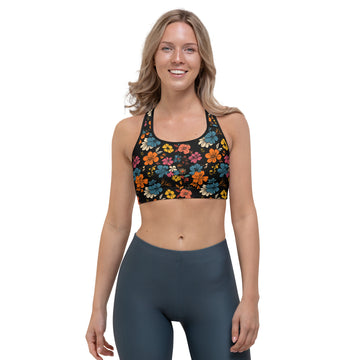 Model wearing a black sports bra with vibrant tropical floral patterns in orange, red, and blue, designed for low to medium-intensity workouts.