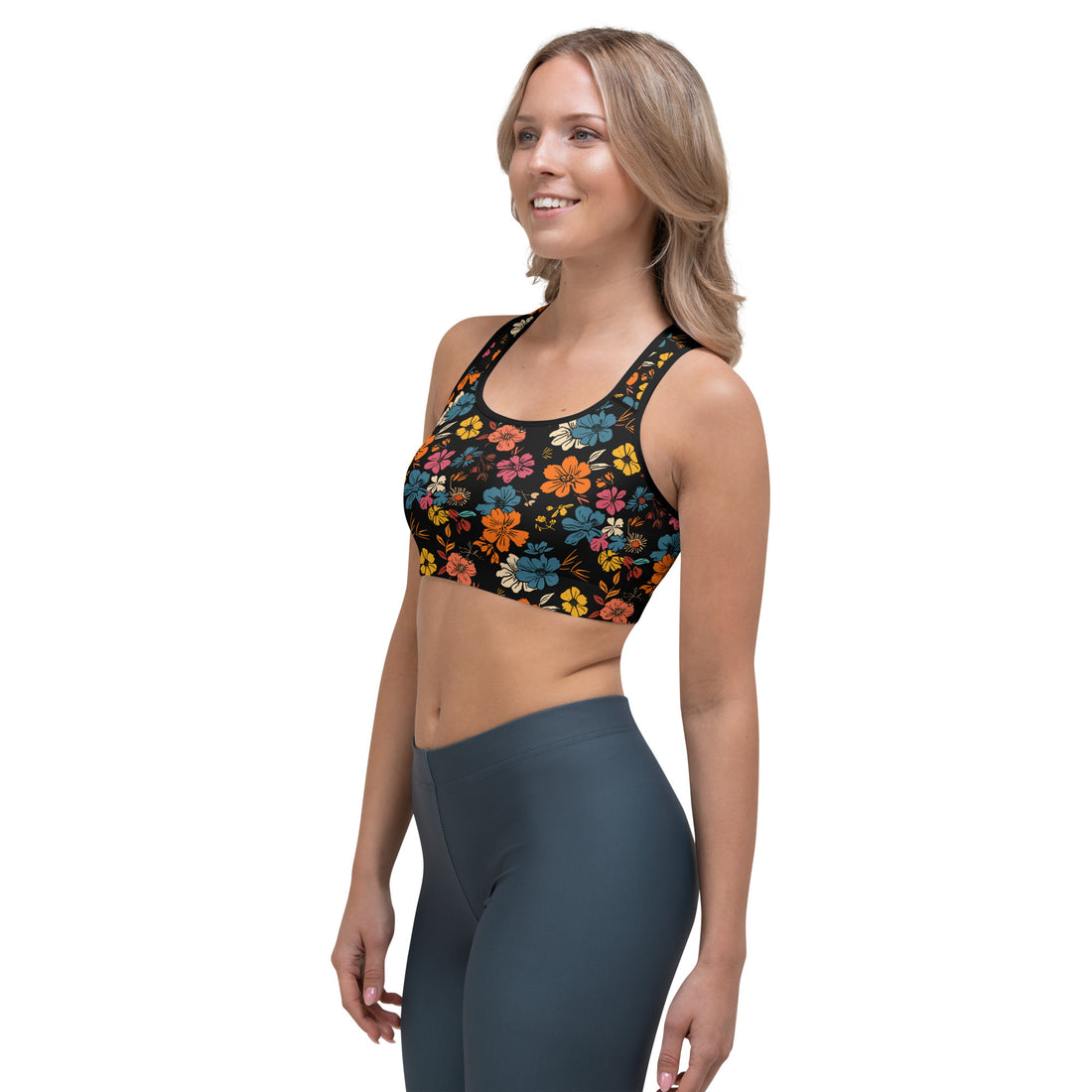 Model wearing a black sports bra with vibrant tropical floral patterns in orange, red, and blue, designed for low to medium-intensity workouts.