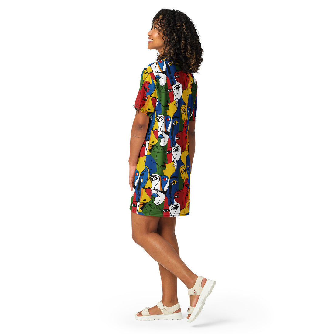 A woman in a colorful oversized T-shirt dress with an abstract face print.