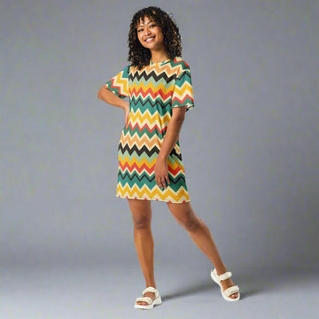 A model wearing a vibrant bohemian zigzag t-shirt dress with colorful chevron patterns.