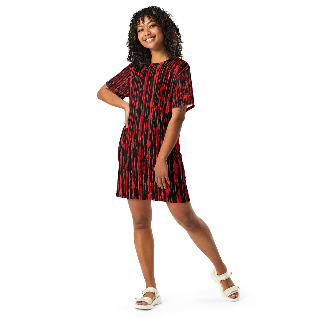 A woman wearing a red and black striped oversized t-shirt dress, perfect for Halloween.