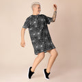 Spooky web print T-shirt dress; black with intricate white web design, comfortable oversized fit, styled casually with black sneakers.