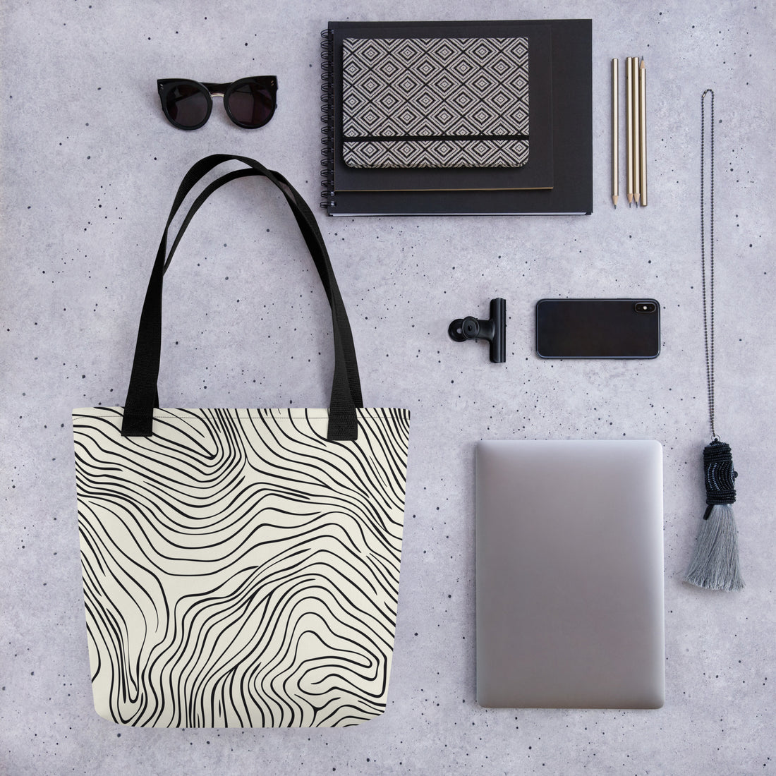 A stylish tote bag with a black and white wave pattern.