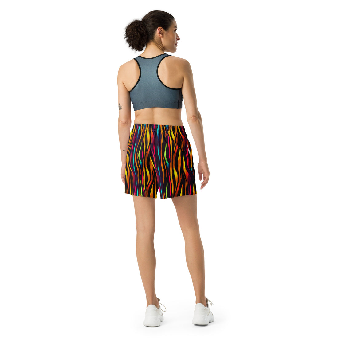 Vibrant unisex athletic long shorts in striped pattern worn by a model.