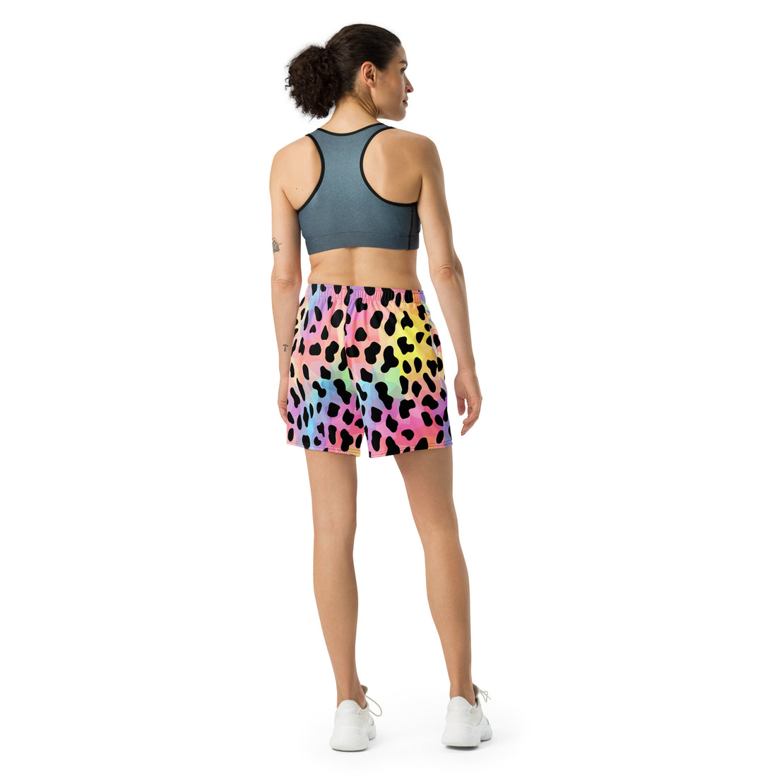 Vibrant leopard print long athletic shorts in multicolor pattern, model showcasing casual athletic wear.