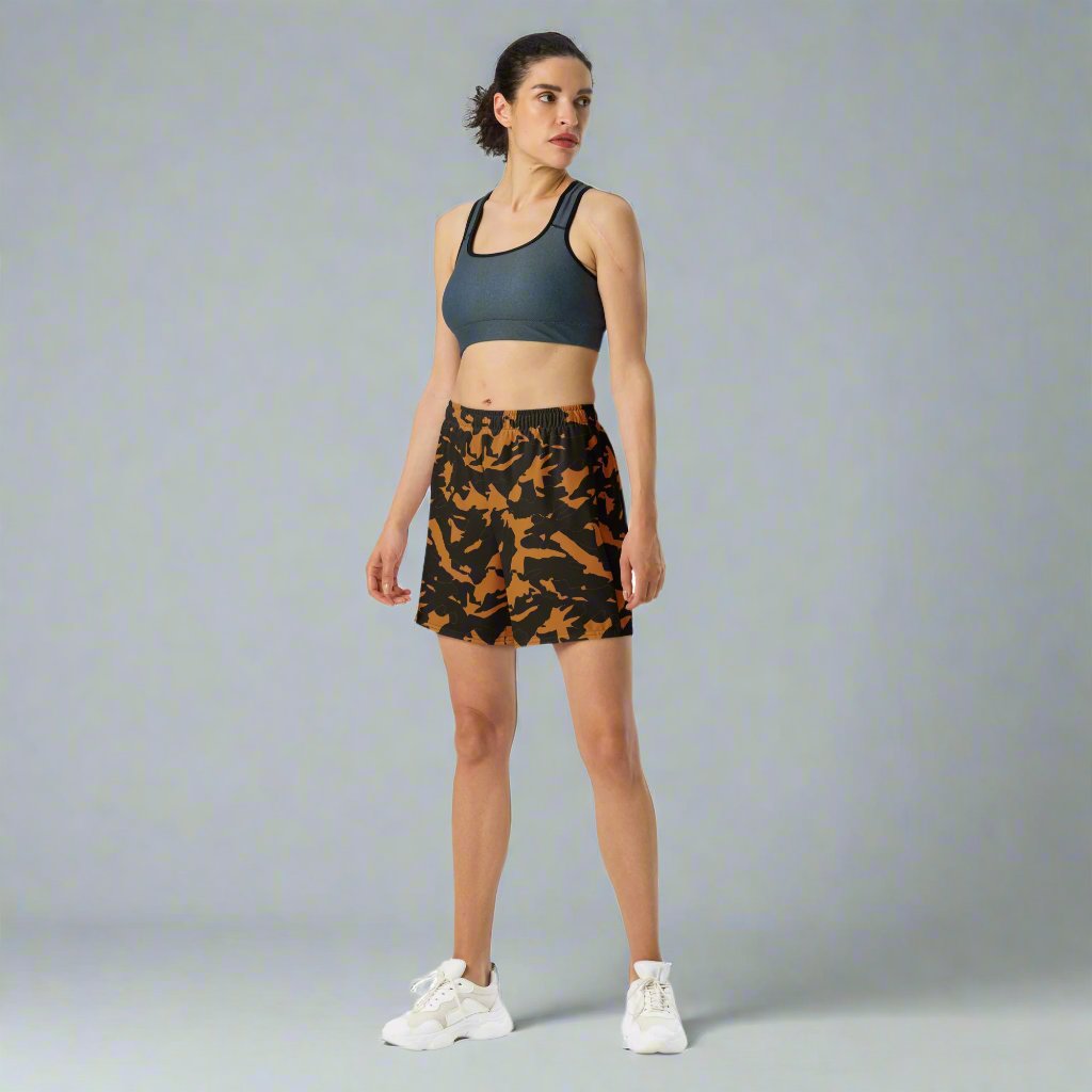 Camo Print Unisex Athletic Long Shorts in black and orange worn by a model