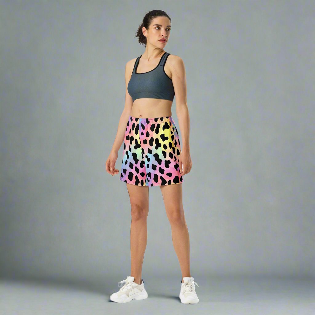 Vibrant leopard print long athletic shorts in multicolor pattern, model showcasing casual athletic wear.