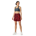 Vibrant leopard print unisex athletic long shorts on a model showcasing the stylish design in red and black.