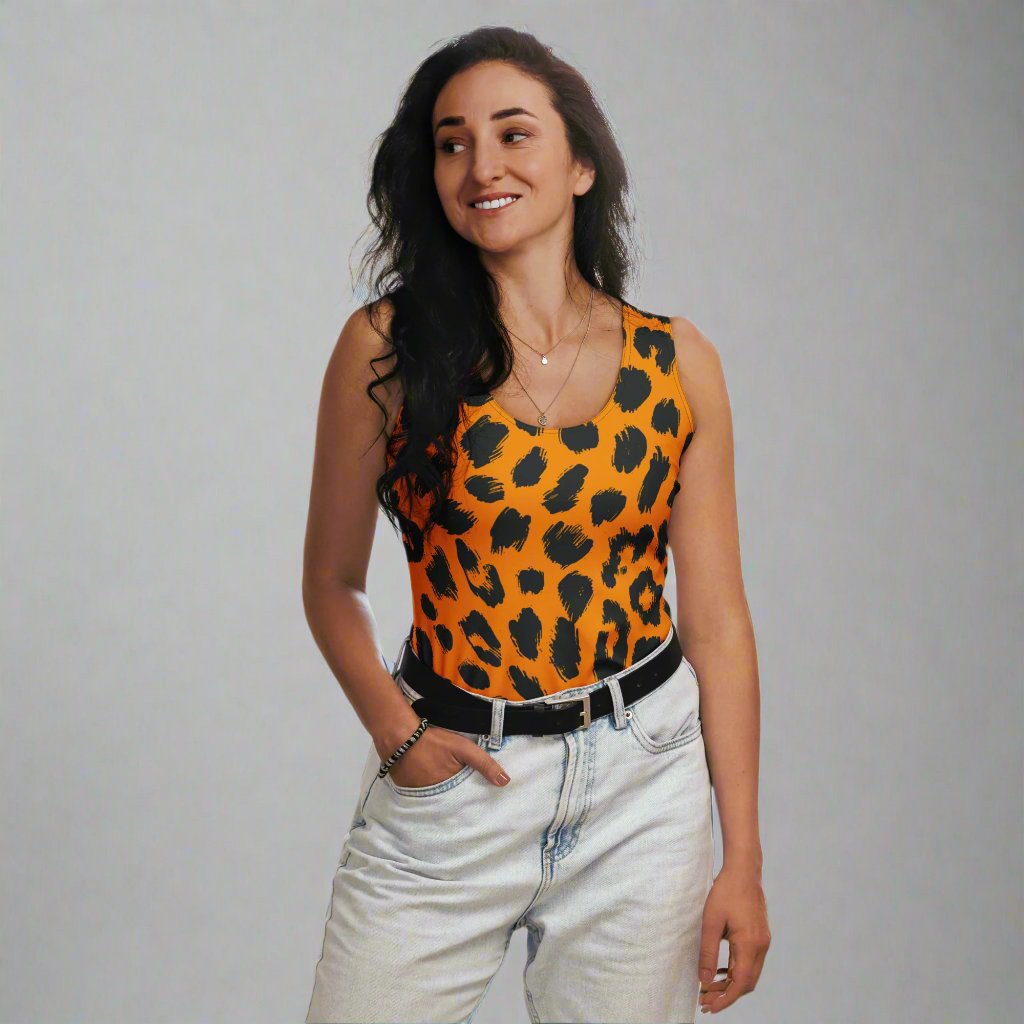 Bold leopard print cut and sew tank top in orange and black, worn by a smiling woman in casual denim.