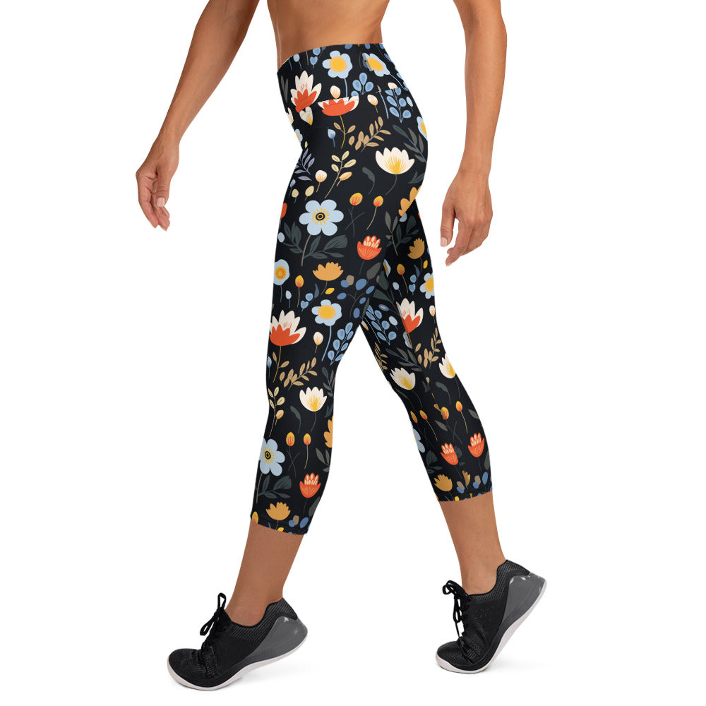 Black yoga capri leggings with vibrant autumn floral designs, featuring red, orange, and blue flowers against a dark backdrop.