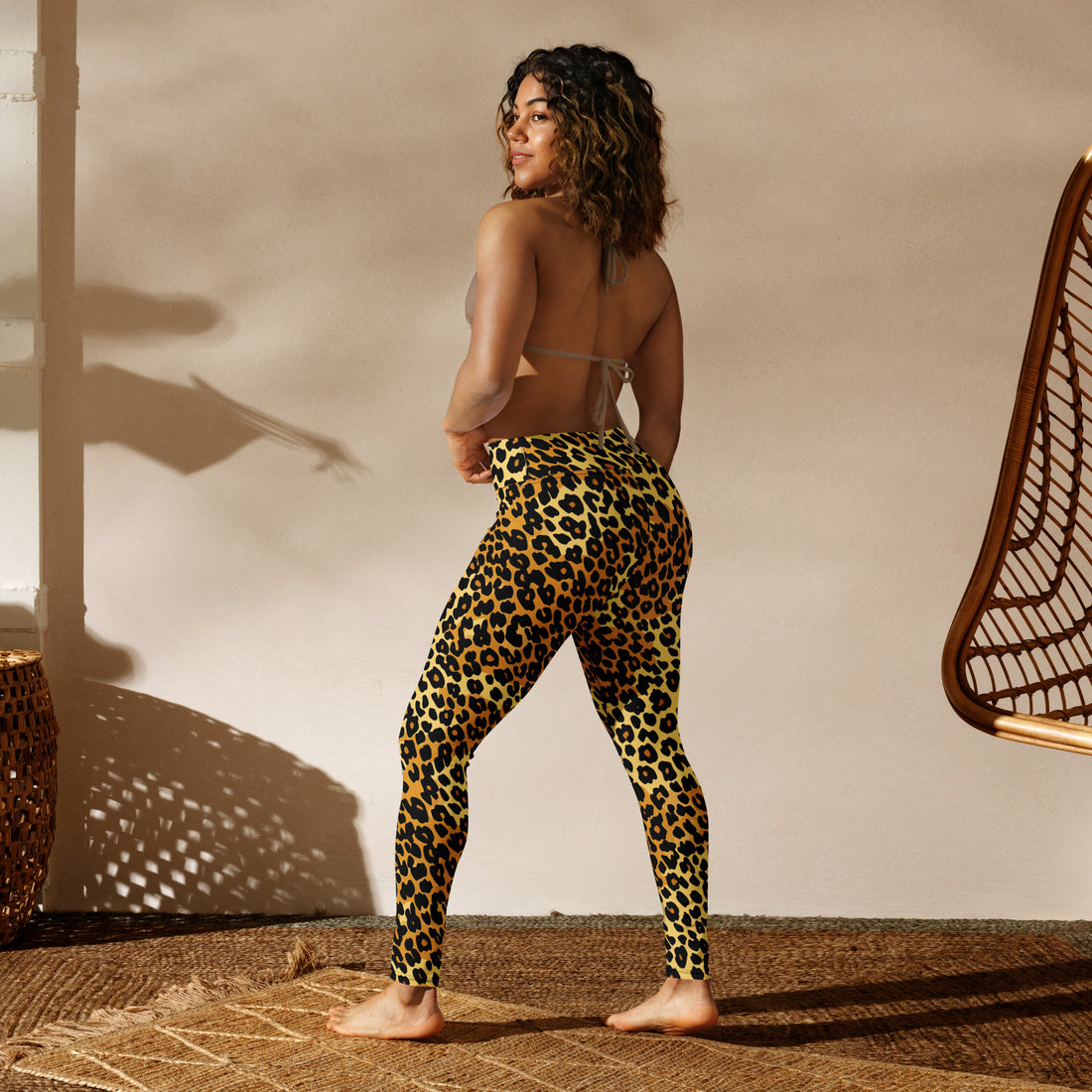 Leopard print yoga leggings with a high waistband worn by a woman holding an exercise mat.