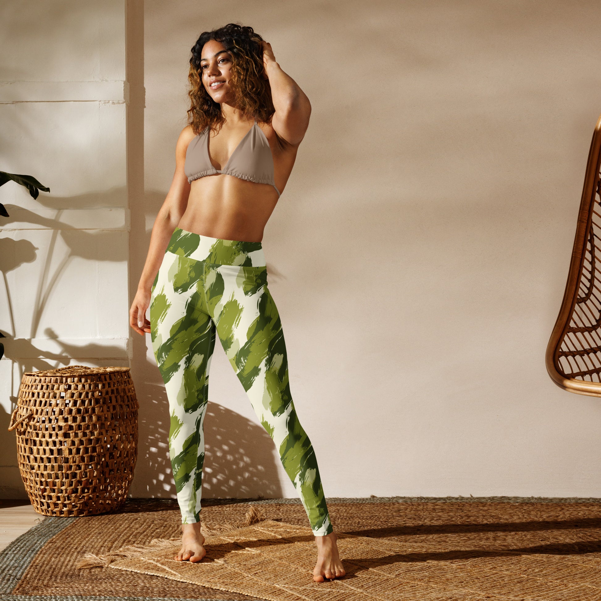 Chic camouflage yoga leggings in green and cream with a raised waistband, worn by a woman in stylish activewear.