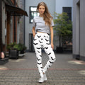 Women wearing white yoga leggings with black bat prints, perfect for Halloween.