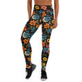 Vibrant floral yoga leggings with orange, teal, yellow, and pink flowers on a black background, displaying a raised waistband.