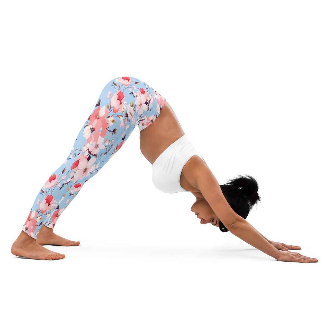 Model wearing yoga leggings with blue background and pink white floral design, in a yoga pose.