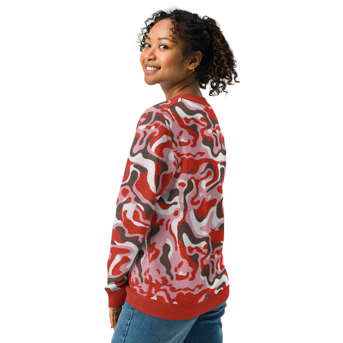 Woman wearing a knitted crew neck sweater with pink, red, and brown abstract patterns, perfect for autumn and winter fashion.