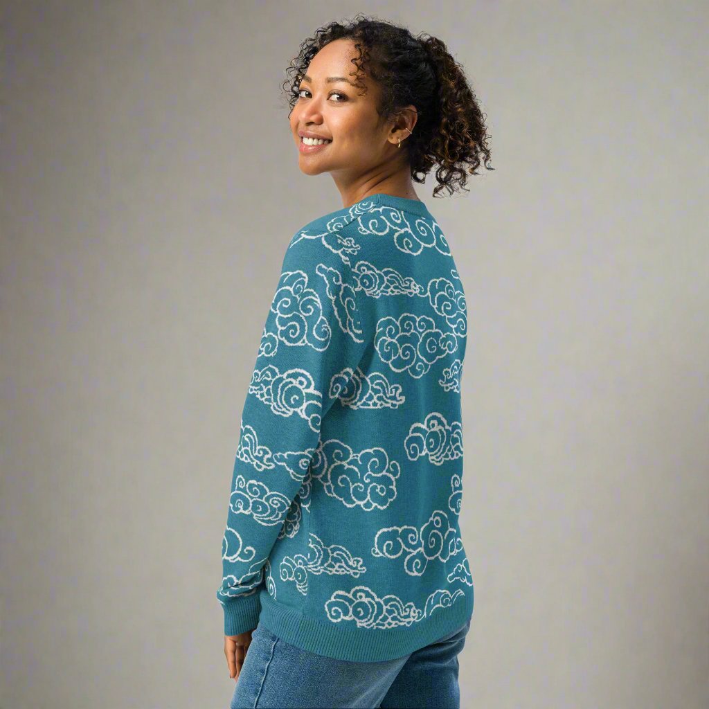 Teal knitted sweater with ivory cloud patterns, showcasing a cozy and stylish design.