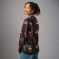 Black knit sweater with vibrant pink and white jellyfish pattern, cozy winter fashion.