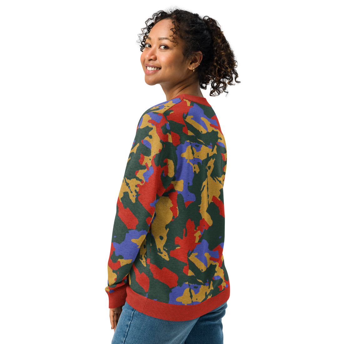 Woman wearing a vibrant autumn camouflage knit sweater with multicolor design in green, brown, and red.