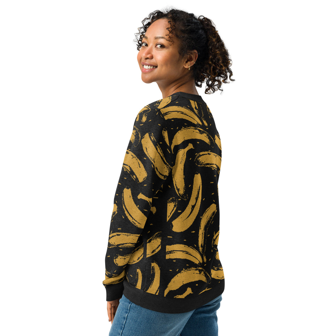 Woman wearing a black and mustard yellow knitted sweater with a playful banana pattern.