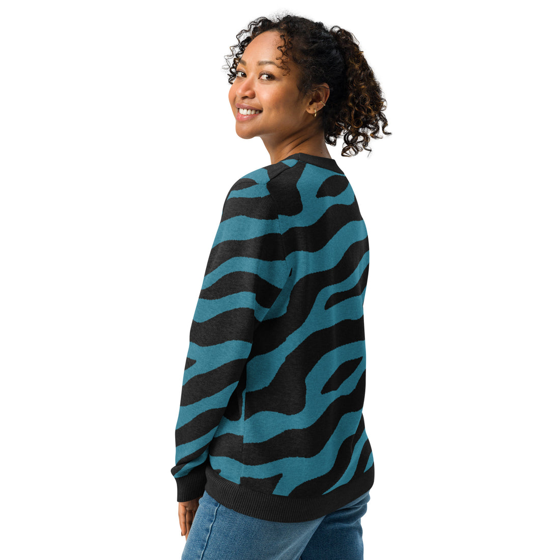 Woman wearing a teal and black zebra striped knitted sweater, showcasing its unique design ideal for fall fashion.