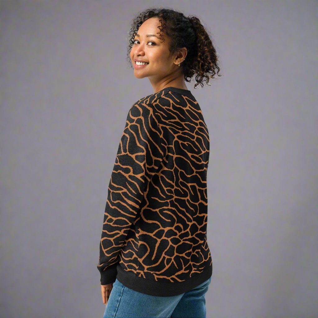 A woman wearing a zebra-patterned knit sweater in warm fall colors, featuring a comfortable crew neck design