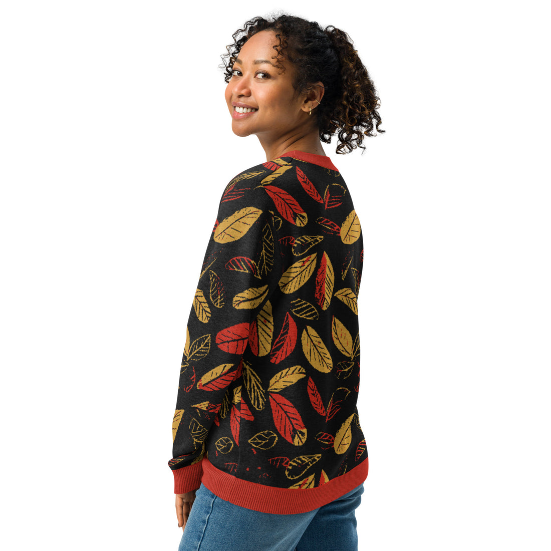 Women's sweater with autumn leaf pattern in red and gold on a black background. Knitted design for fall fashion.