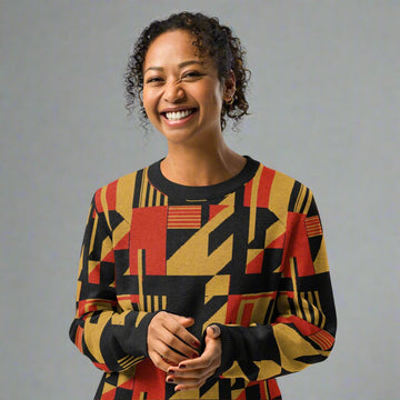 Woman wearing a knitted sweater featuring a bold geometric pattern in red, gold, and black, ideal for fall fashion trends.