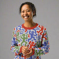 Colorful abstract figure knitted sweater with playful multicolored design, featuring vibrant red, green, and blue hues.