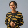 Woman wearing a black and mustard yellow knitted sweater with a playful banana pattern.