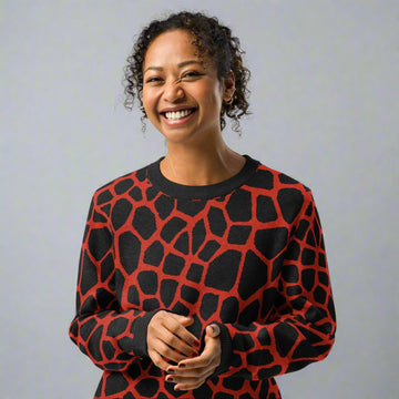 Woman wearing a black and red giraffe pattern knitted crew neck sweater, showcasing seasonal fall fashion.