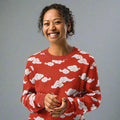 Cozy knitted crew neck sweater with white cloud design on red background.