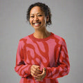 Woman wearing a coral and pink zebra pattern knitted sweater, soft and comfortable with a warm winter style.