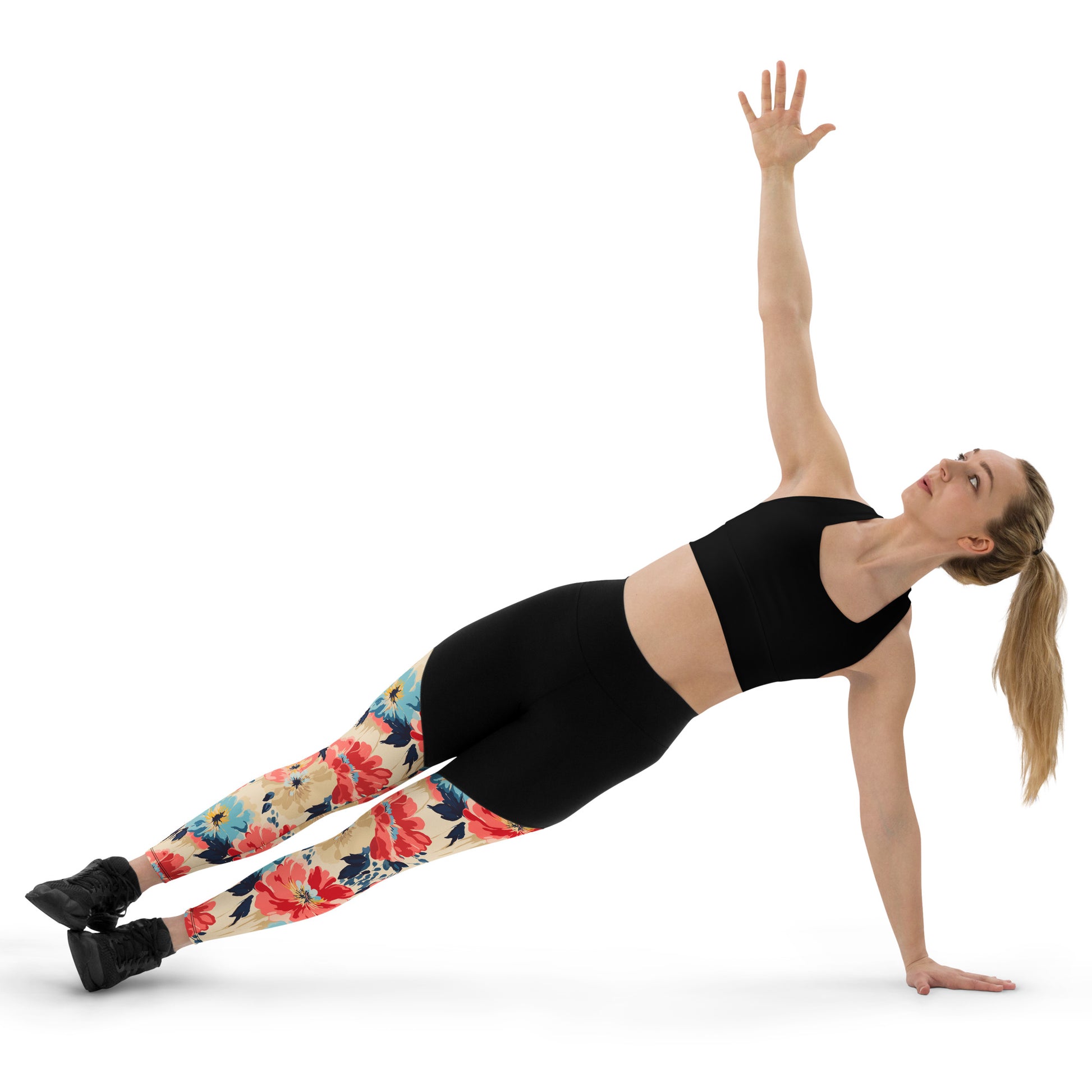 Woman in black sports bra and Floral Fusion Compression Leggings with vibrant blossom design, performing a side plank pose. Winter fashion activewear.