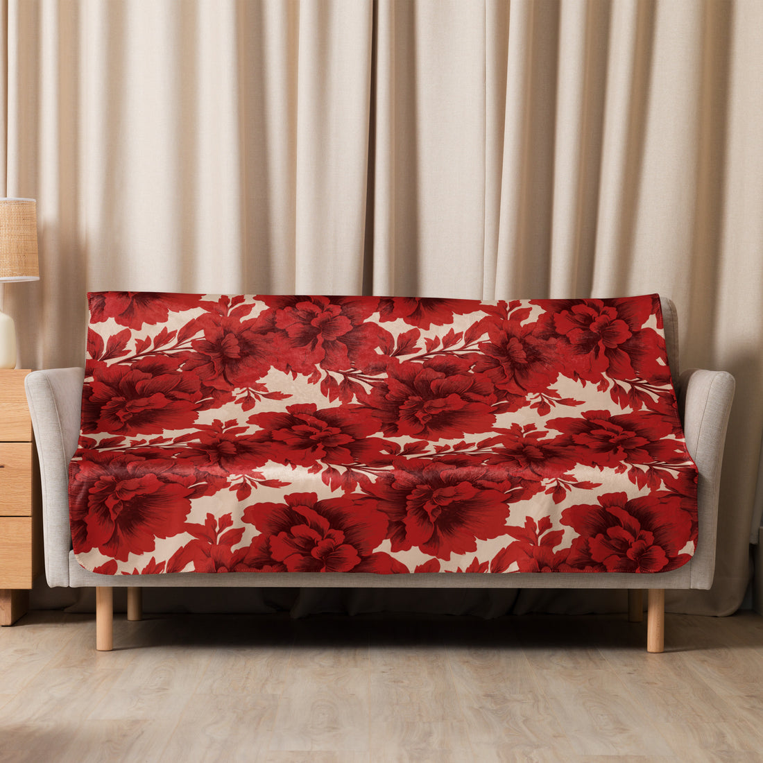 Sherpa blanket draped over a chair, featuring a vibrant scarlet floral pattern on a smooth fabric, suitable for fall and winter decor.