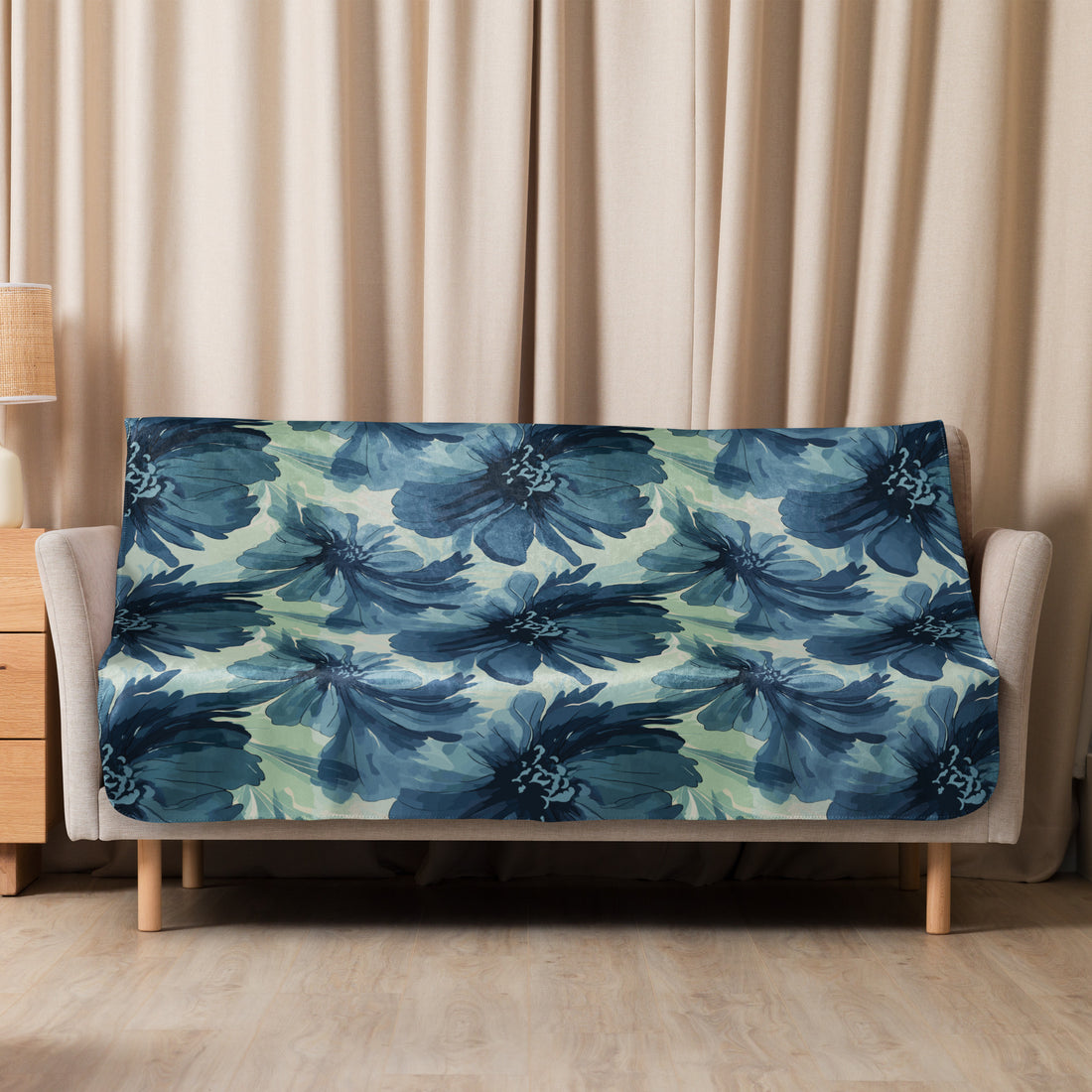 Navy floral sherpa blanket with deep blue floral design on a cozy fabric, draped over a couch.