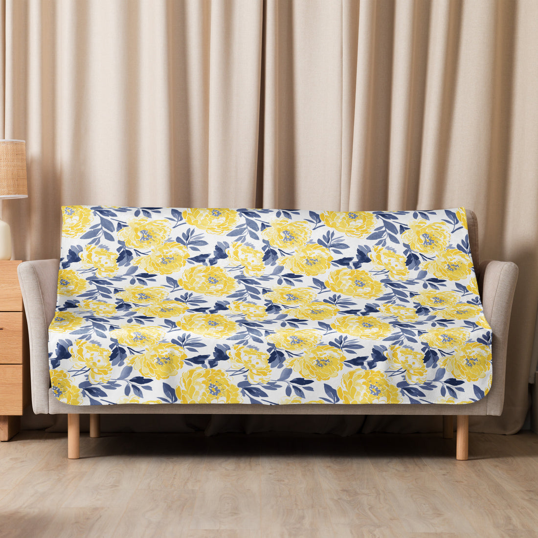 Yellow floral patterned Sherpa blanket draped over a couch, showcasing vibrant yellow flowers against a soft winter-ready design.