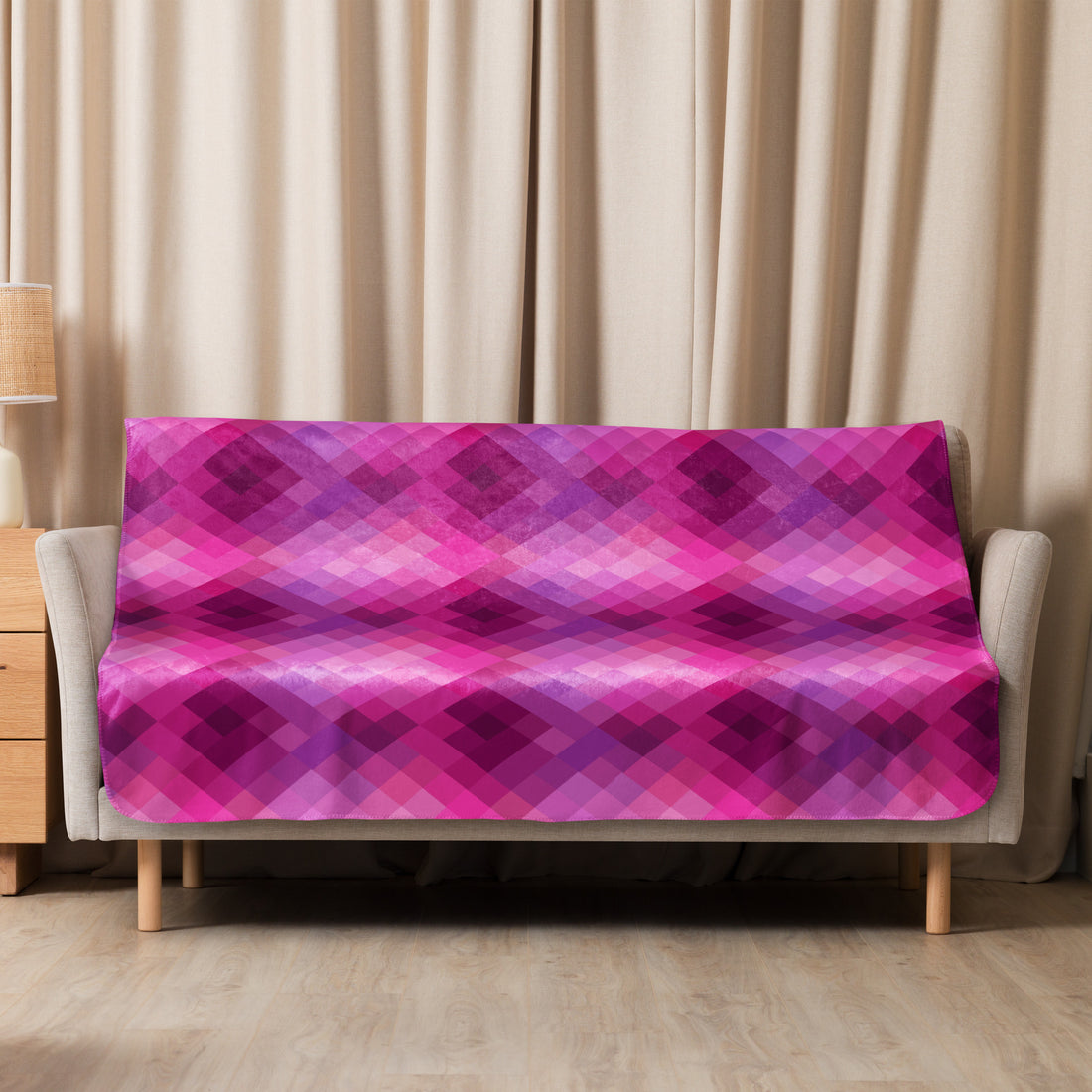 Luxurious pink plaid sherpa blanket draped over a couch, offering a cozy and stylish winter touch to your living room.